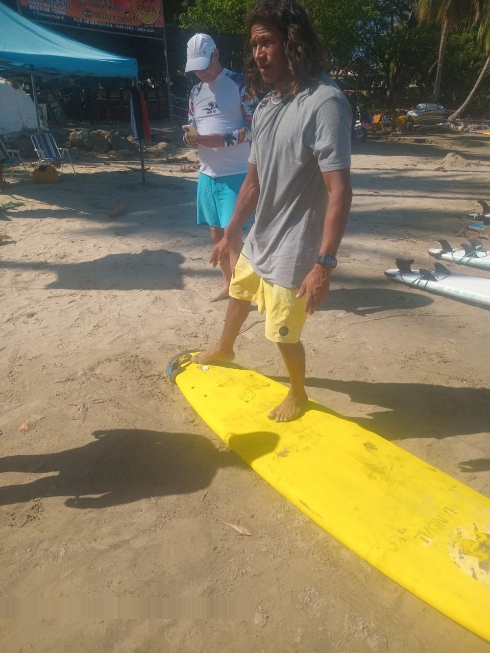 Wilmar on his yellow surfboard in Tamarindo